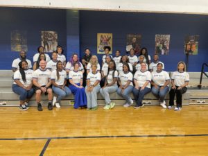 Principal Butler with her staff, all smiling at camera