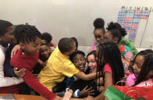 Erin Huseby being embraced by her students