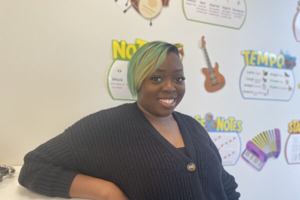 Ms. Bryan smiling into the camera inside her classroom