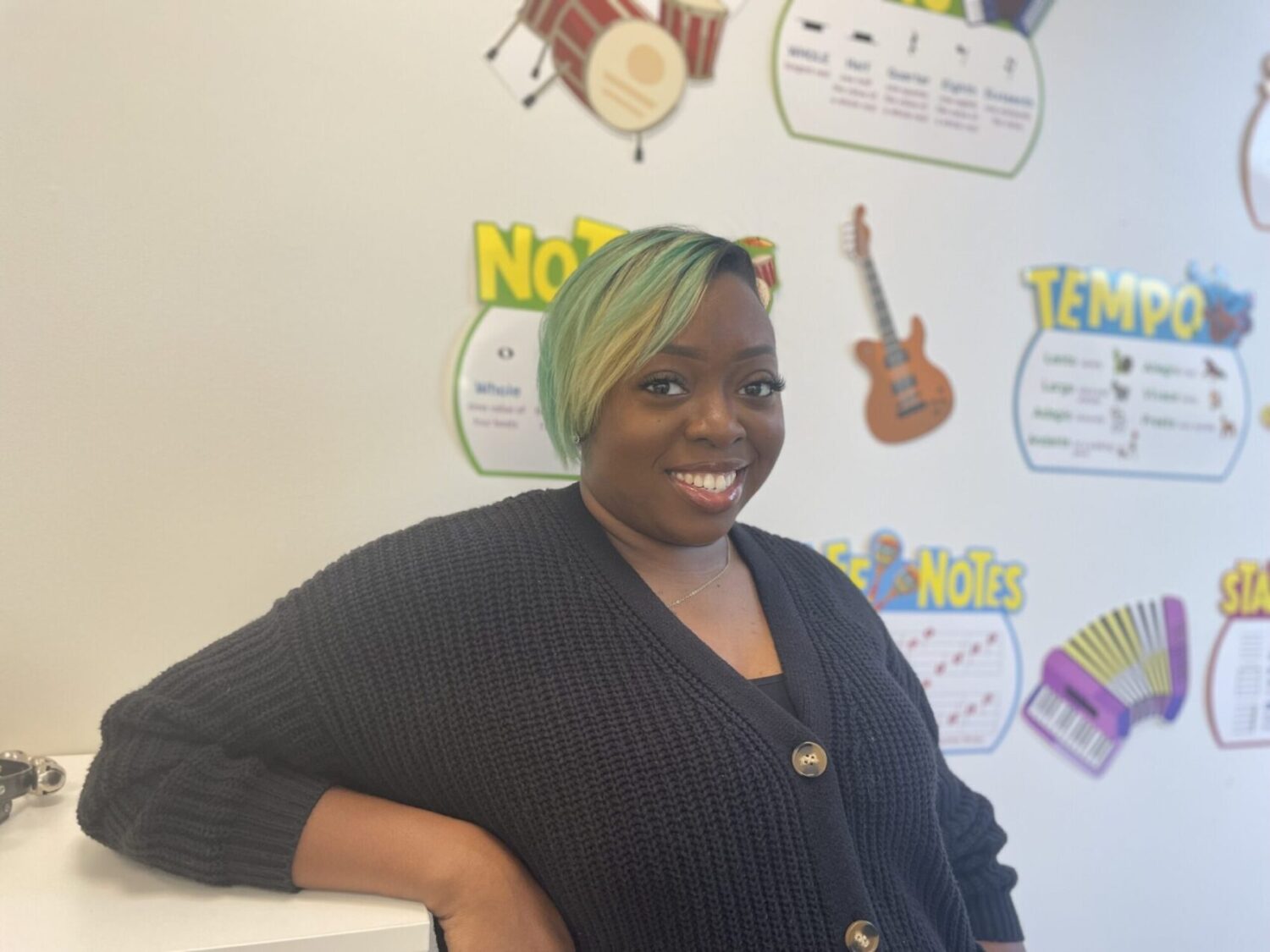 Ms. Bryan smiling into the camera inside her classroom