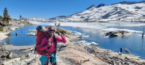 Student giving a thumbs up with mountain scenery behind her