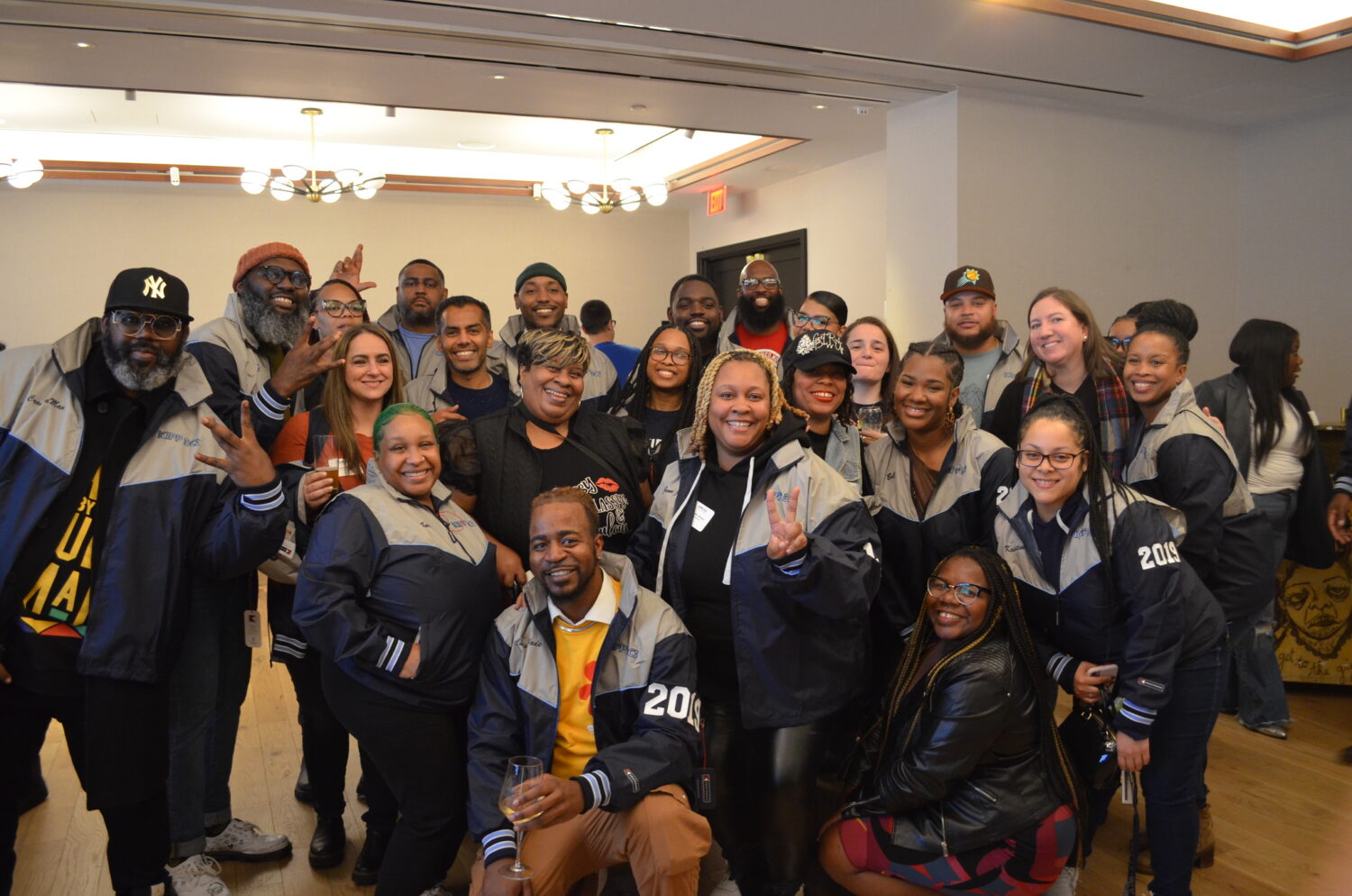 5 Year Jacket Ceremony attendees smiling at the camera while wearing their jackets