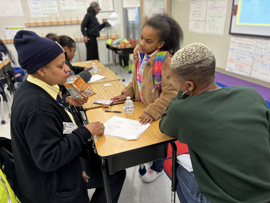 People in classroom solving math problems